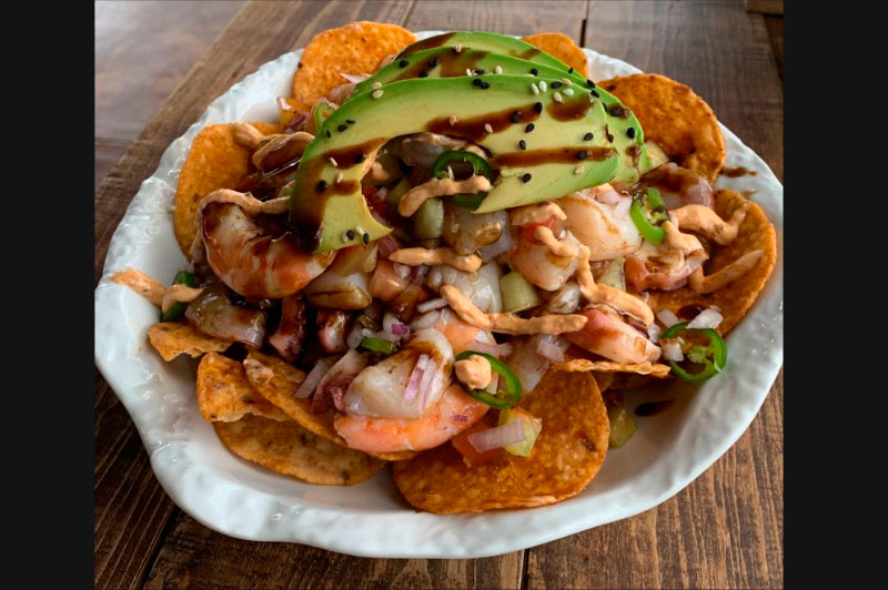 Tostitos con camarón cocido, pulpo y callo en salsas negras, aguacate y alioli chipotle en La Barracuda